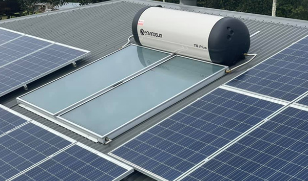 Solar hot water system installed on a metal roof alongside PV panels on the Sunshine Coast