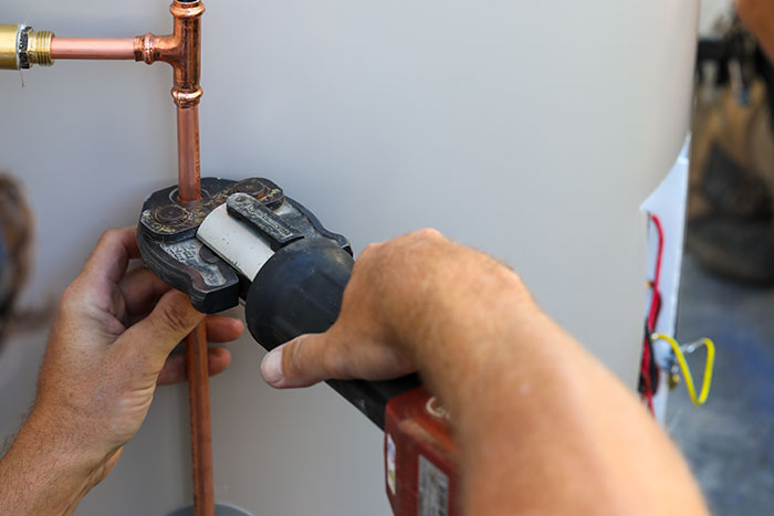 Plumber fitting copper pipes on a hot water system on the Sunshine Coast